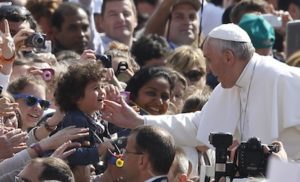 Pope blesses child as he arrives to lead general audience at Vatican
